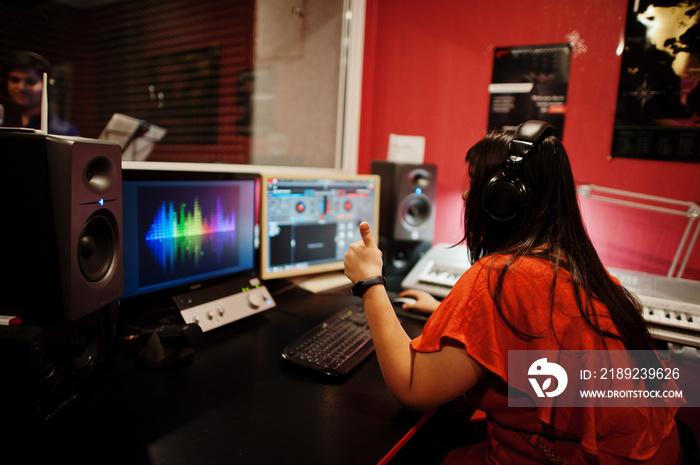 Young asian singer man with microphone recording song in record music studio with sound producer.