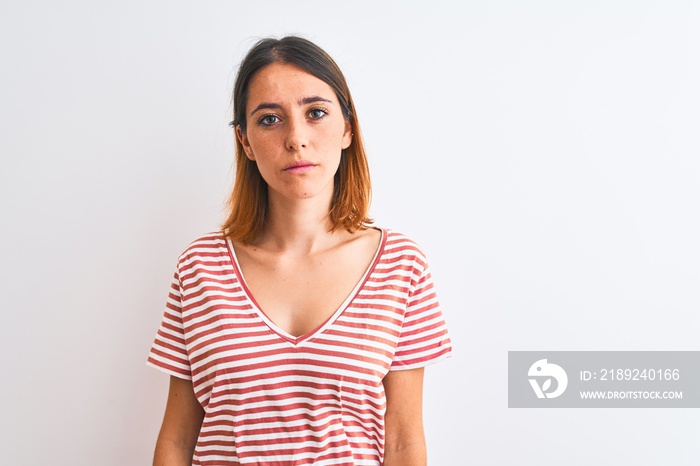 Beautiful redhead woman wearing casual striped red t-shirt over isolated background Relaxed with ser