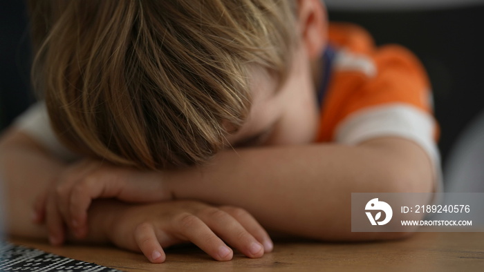 Bored little boy Child covering face in boredom