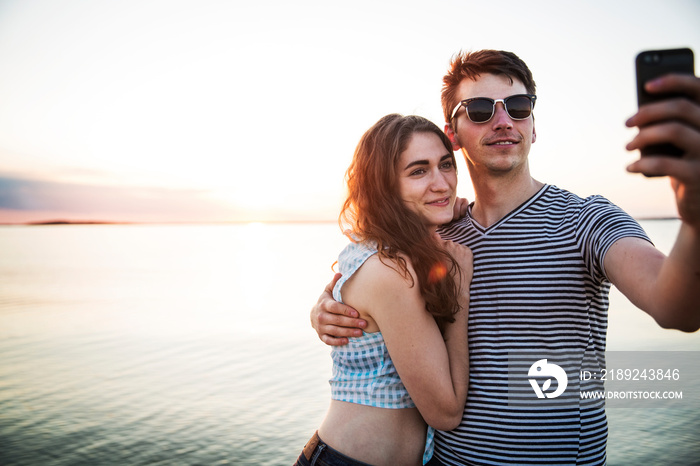 Young couple taking selfie by sea