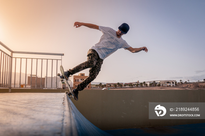 joven skater haciendo un truco llamado 5-0 en rampa. Detrás de él, el sol está cayendo