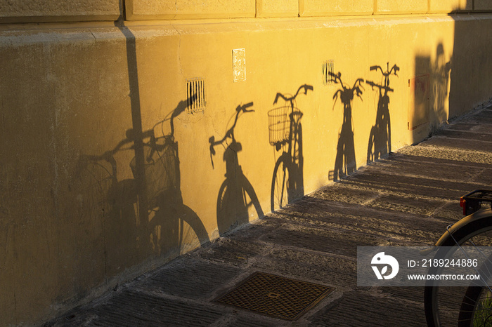 Shadows of bicycles against a wall in Florence Italy.