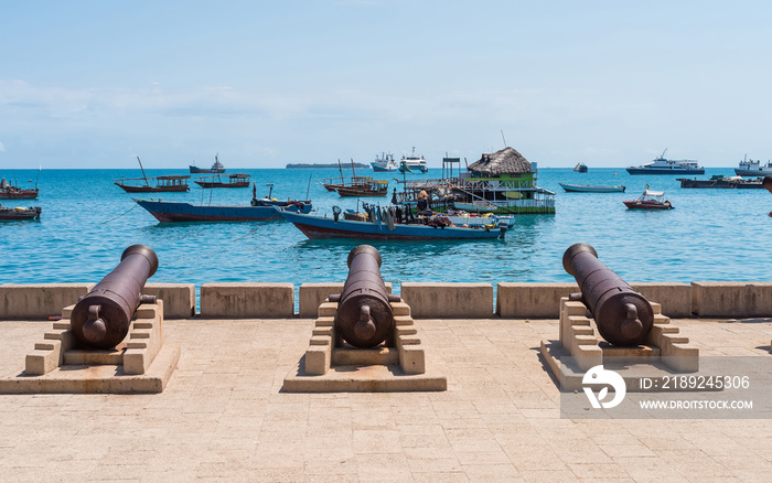 embankment with guns in Zanzibar Stone Town with boats in ocean and sky on the background