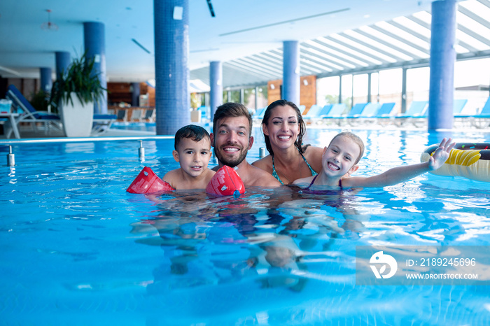 Young couple having fun with their children in the water