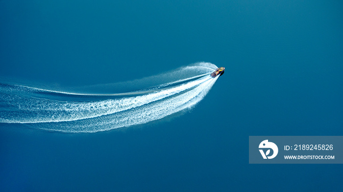 The jet ski travels at great speed through blue water