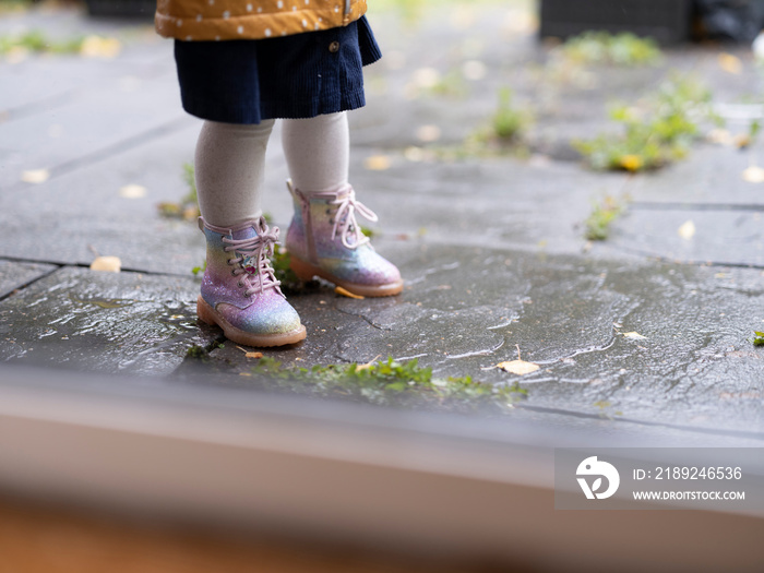 Girl standing in rain, low section�