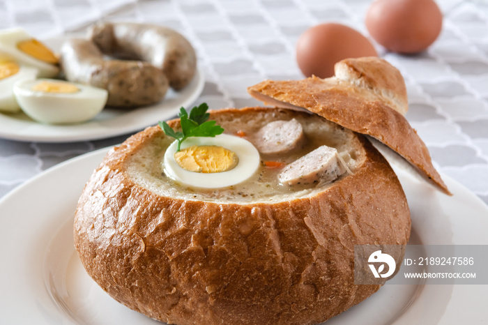 The sour soup (zurek) made of rye flour with sausage and egg served in bread bowl. Popular Easter di