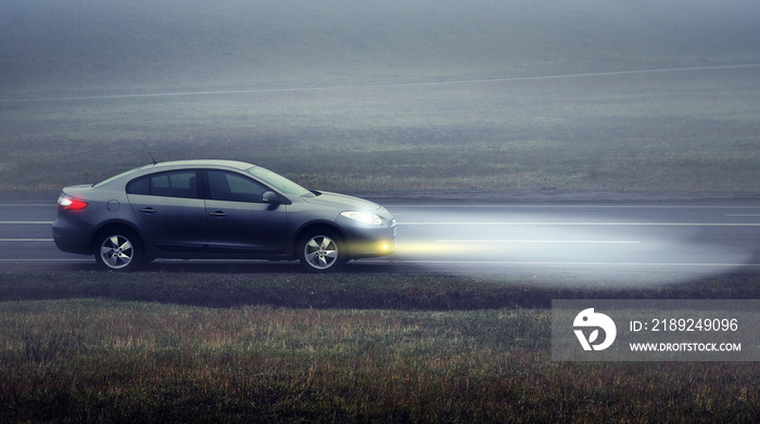 Car on the road in the evening with the dimensions and lights on.