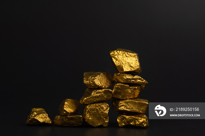 A pile of gold nuggets or gold ore on black background, precious stone or lump of golden stone, fina