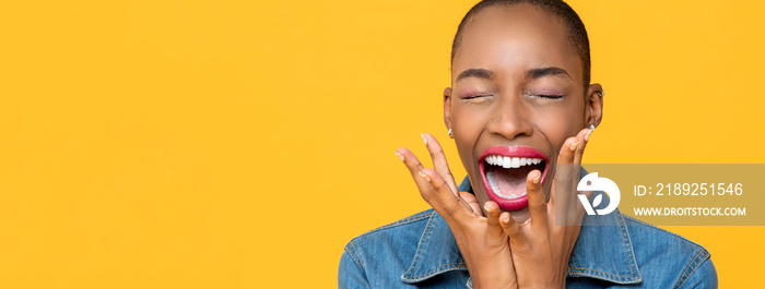 Panoramic close up portrait of ecstatic young African American woman screaming with hands covering f