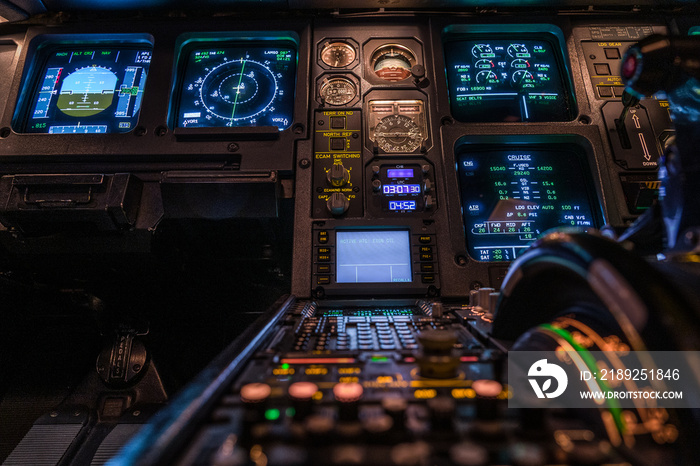 modern airplane cockpit with illuminated instruments - detail view - during night time flight - blur