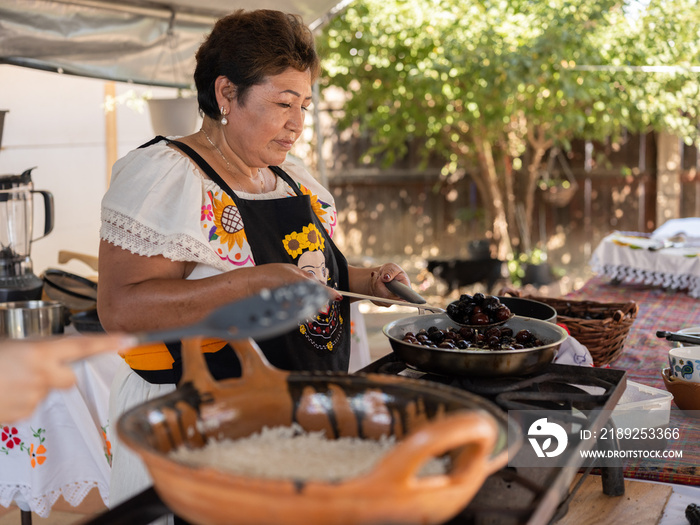 一位土著母亲在锅里做饭的侧视图