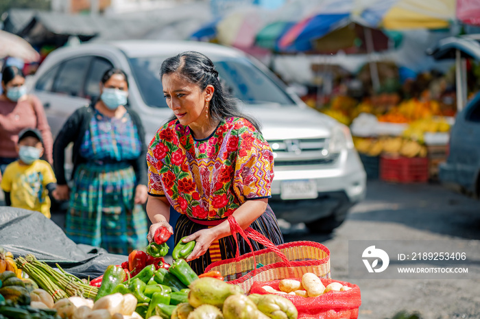 Mujer Indigena comprando en el mercado con un hermoso traje tiìco de Quetzaltenango.