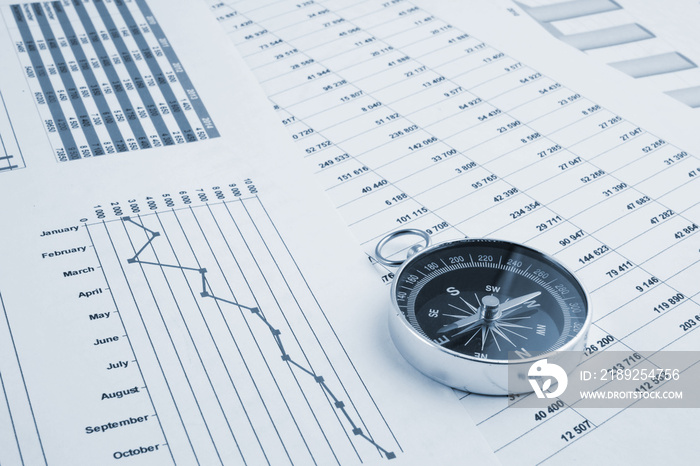 Navigation in financial world, compass on financial charts and graphs