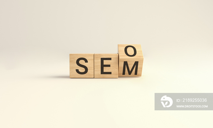 SEO vs SEM. Wooden cube block flip over word SEO to SEM on Yellow studio background.