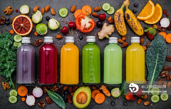 瓶装彩色健康奶昔和果汁，搭配深色的新鲜热带水果和超级食品