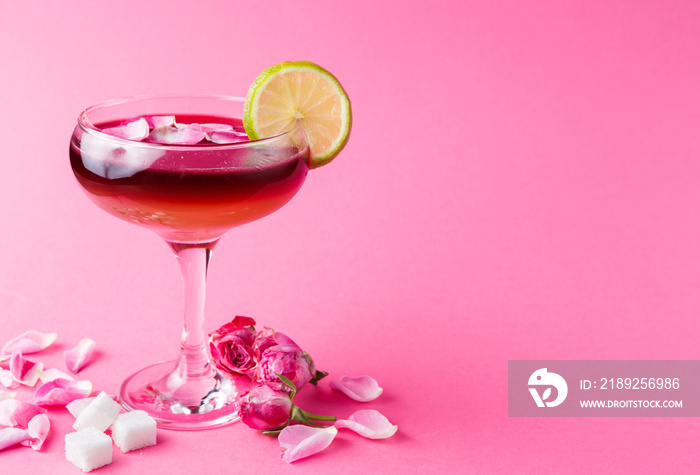 Rose cocktail in champagne glass on pink background