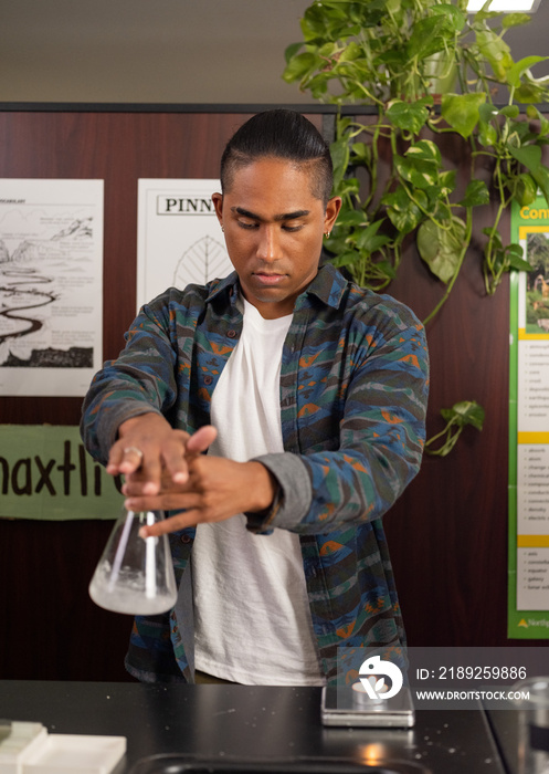 Native boy stirring a flask