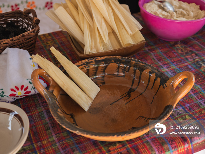 Dinner table with a clay pot that has prepared tamales