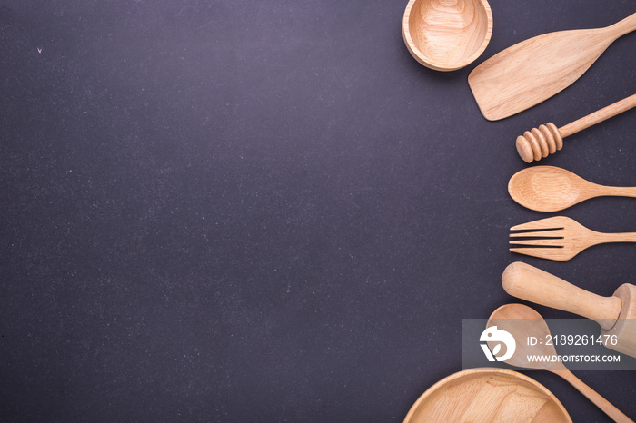 Collection of new wooden kitchen utensil, bowl, plate, spoon, dish. Studio shot on black table. With