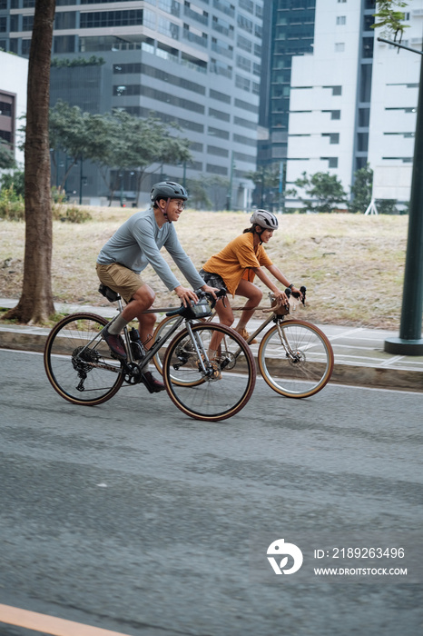 A young couple riding their bikes together in the city.