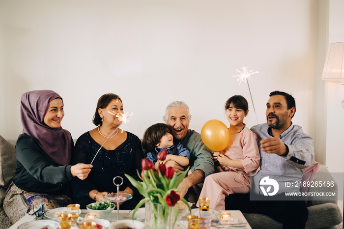 Happy family enjoying birthday party in living room at home