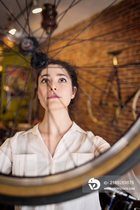 Young woman holding bicycle wheel