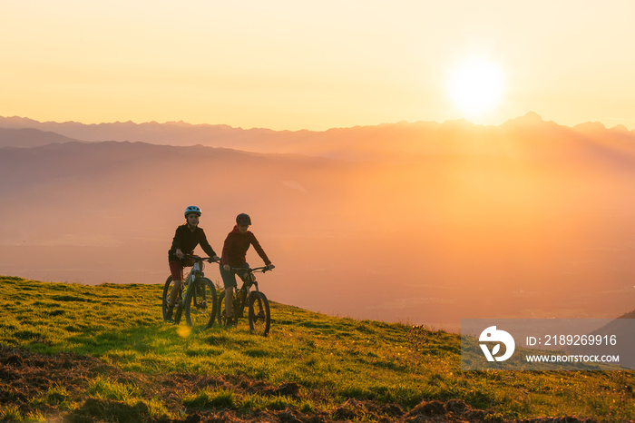 日落时分，母女俩骑着山地自行车上坡。
