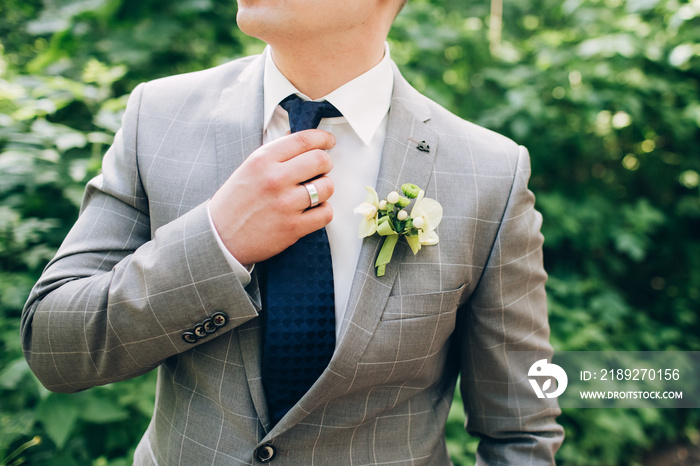 stylish groomsmen helping happy groom getting ready in the morning for wedding ceremony. luxury man 