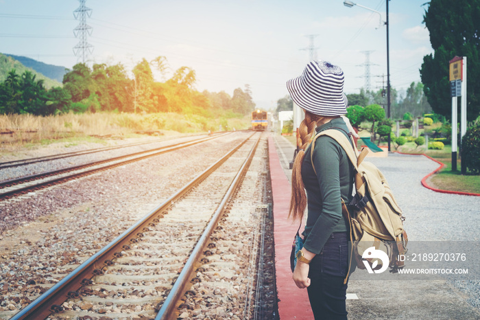 Traveler woman walking and waits train on railway platform