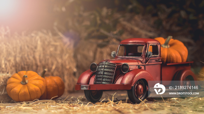 秋天的构图。红色皮卡车，南瓜和稻草包。农场乡村风格的装饰。哈