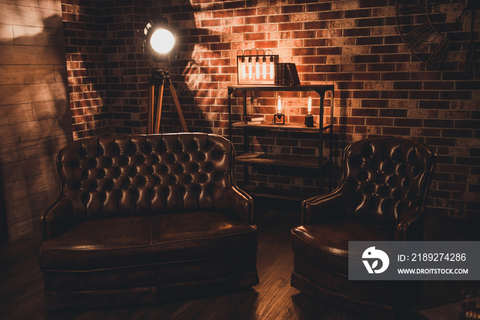 Loft interior. Leather couch and armchair in a dark room