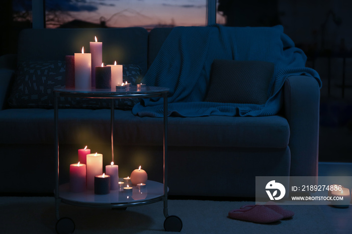 Burning candles on table in dark room