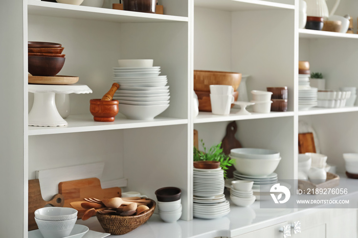 厨房里有陶瓷和木制餐具的白色储物架