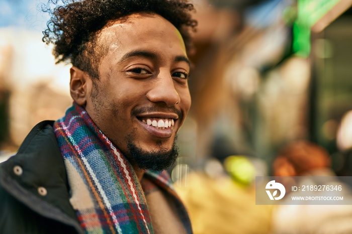 Young african american man smiling happy standing at the city