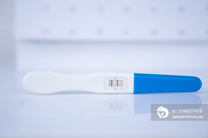 Closeup pregnancy test with calendar background, health care concept, selective focus