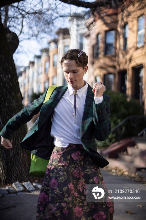 non-binary caucasian person with short hair dancing on Brooklyn sidewalk