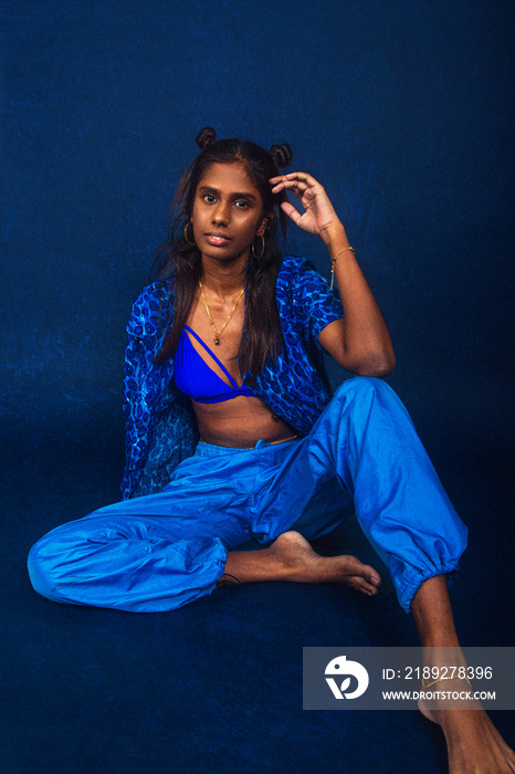 portrait of dark skinned Indian woman from Malaysia against dark blue background