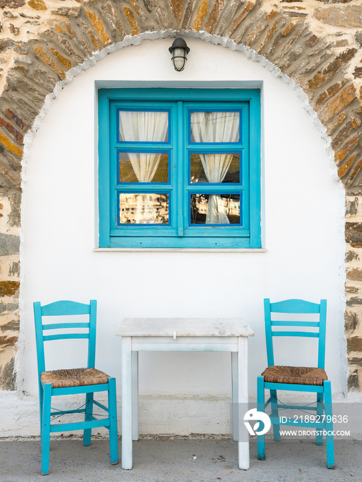 view to traditional greek taverna with two chairs