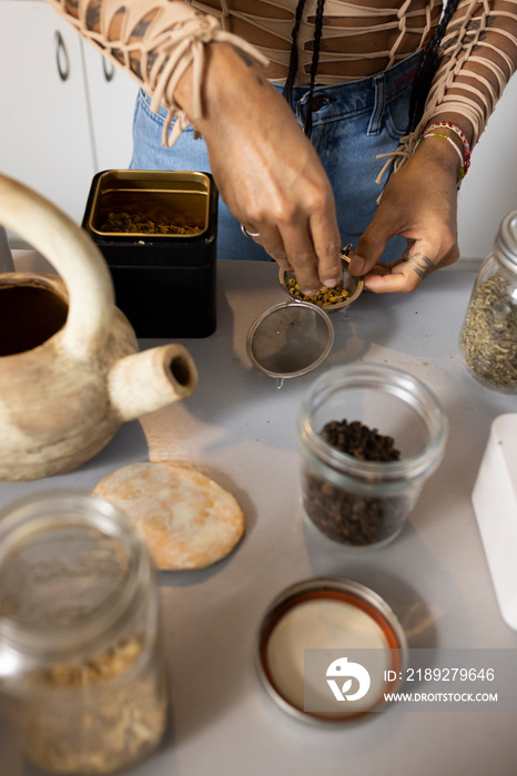 indigenous non-binary artist hands making tea in kitchen