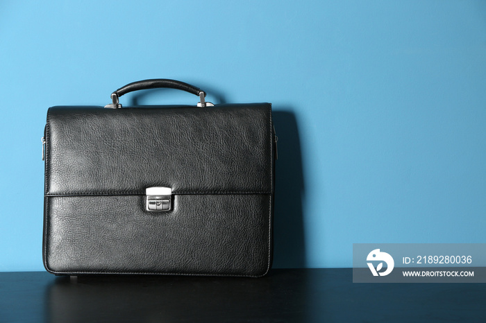 Male briefcase on table against color background