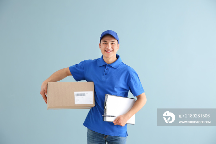 Delivery man with box and clipboard on color background