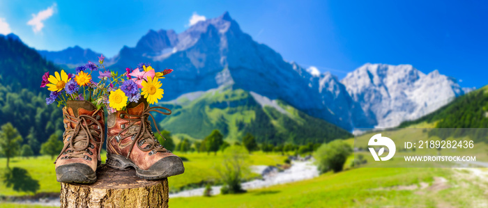 Wanderschuhe mit Blumen in schöner bayerischer Landschaft