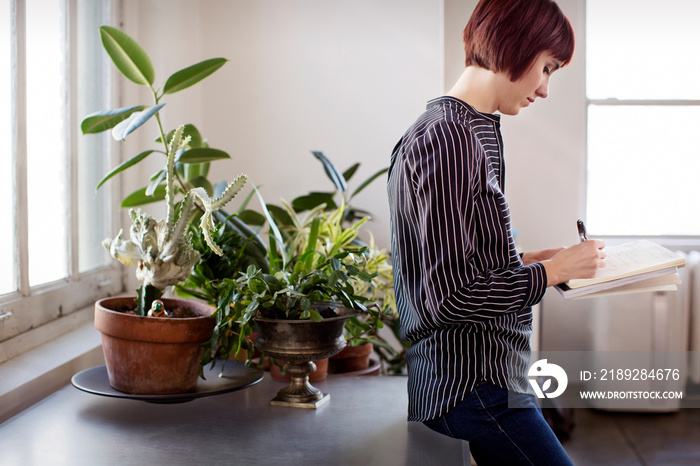 Confident businesswoman writing in note pad