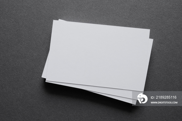 Mock up a stack of blank white cards ün a grey table, space for text or a template