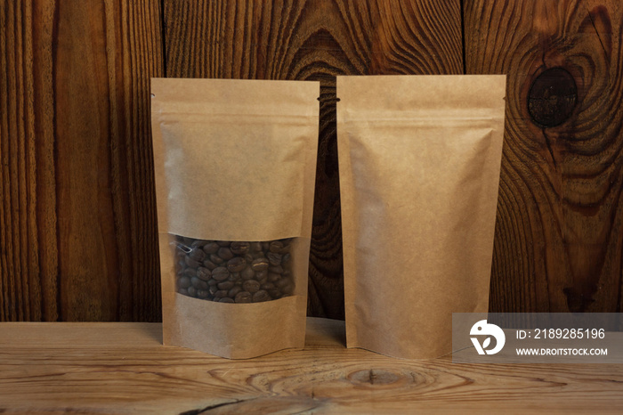 棕色牛皮纸袋，木质背景咖啡豆正面图。食品包装