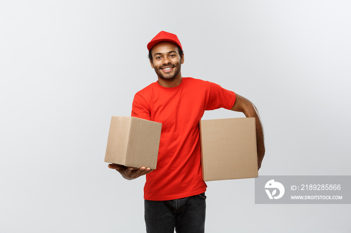 Delivery Concept - Portrait of Happy African American delivery man in red cloth holding a box packag