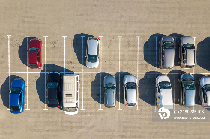 停车场上停着许多五颜六色的汽车的鸟瞰图，停车位有线条和标记a