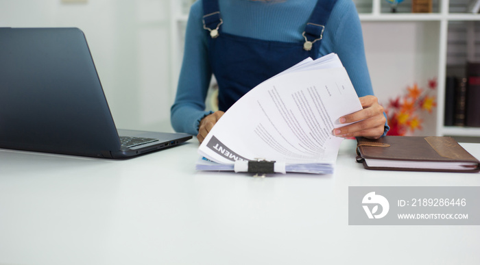 Female auditors work with documents at their desks in the office.