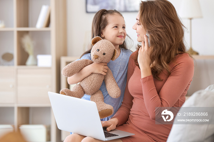 Working mother with little daughter at home